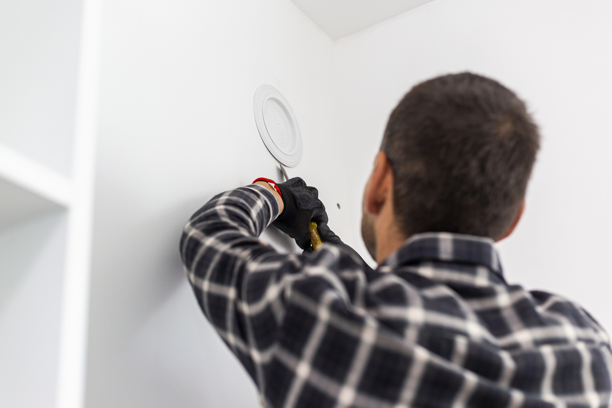 Hausmeister entfernt Lüftungsschachtabdeckung